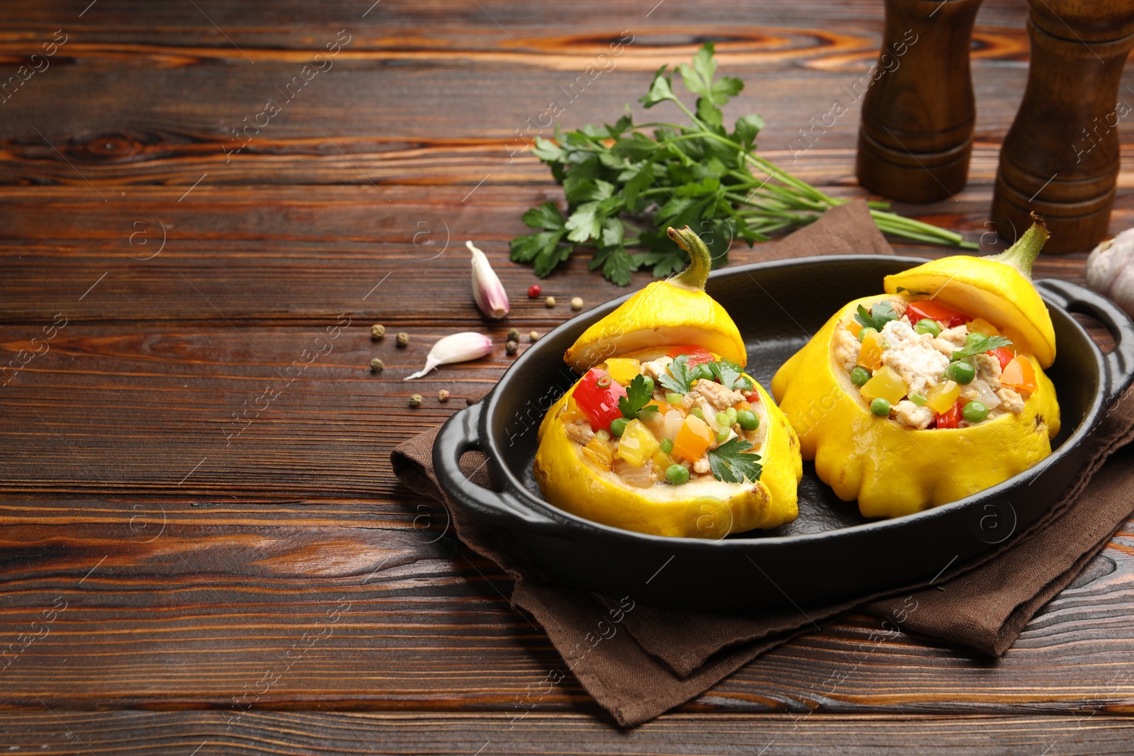 Photo of Tasty stuffed pattypan squashes in baking dish on wooden table. Space for text