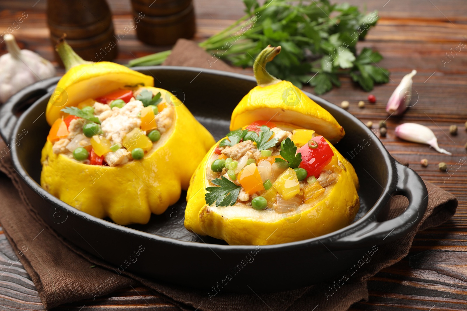 Tasty stuffed pattypan squashes in baking dish on wooden table, closeup Photo of Tasty stuffed pattypan squashes in baking dish on wooden table, closeup