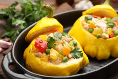 Photo of Tasty stuffed pattypan squashes in baking dish on table, closeup
