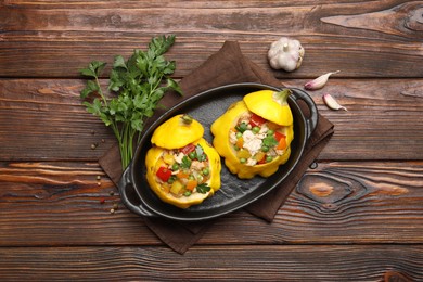Photo of Tasty stuffed pattypan squashes in baking dish on wooden table, flat lay