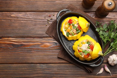Photo of Tasty stuffed pattypan squashes in baking dish on wooden table, flat lay. Space for text