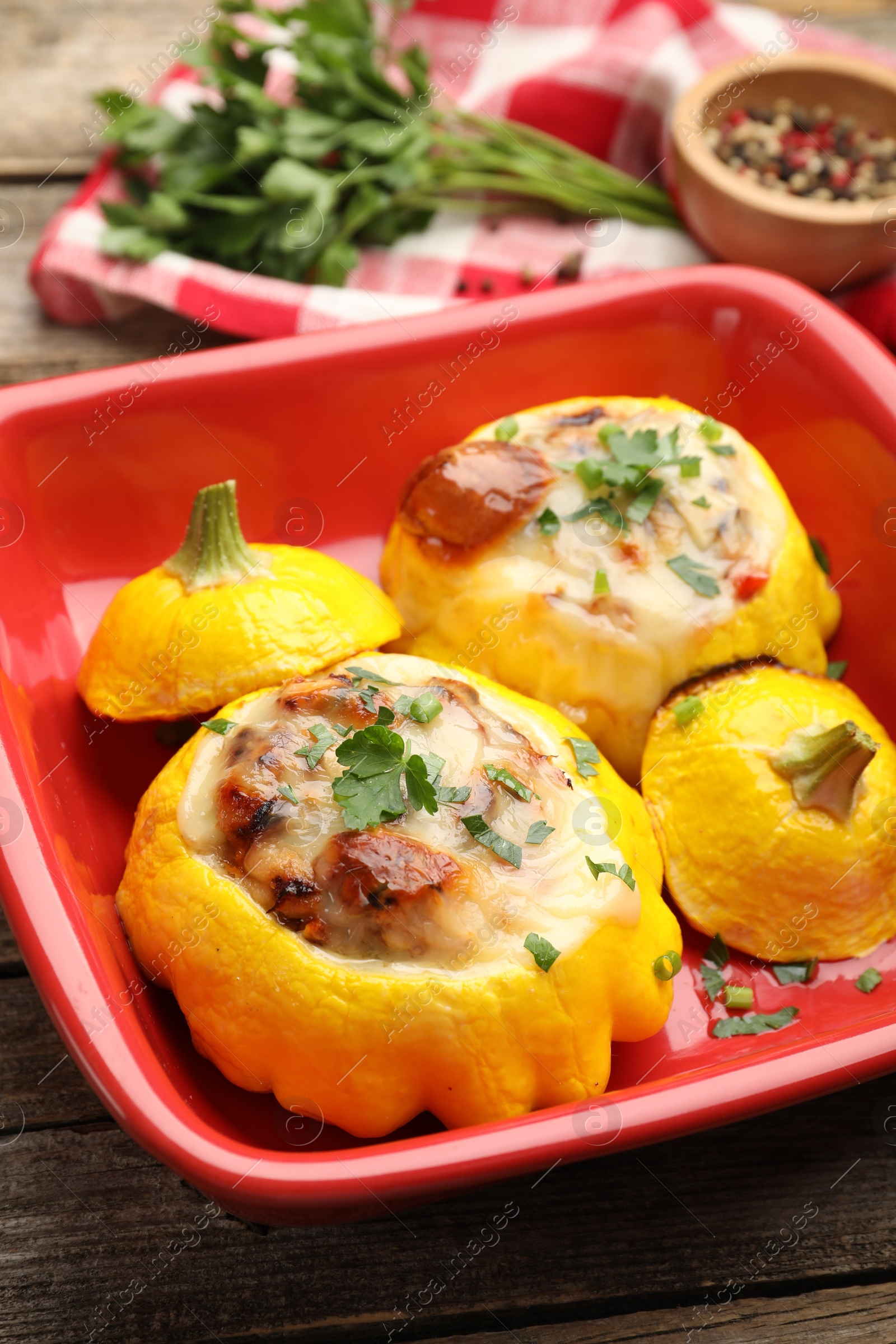 Tasty stuffed pattypan squashes in baking dish on wooden table, closeup Photo of Tasty stuffed pattypan squashes in baking dish on wooden table, closeup