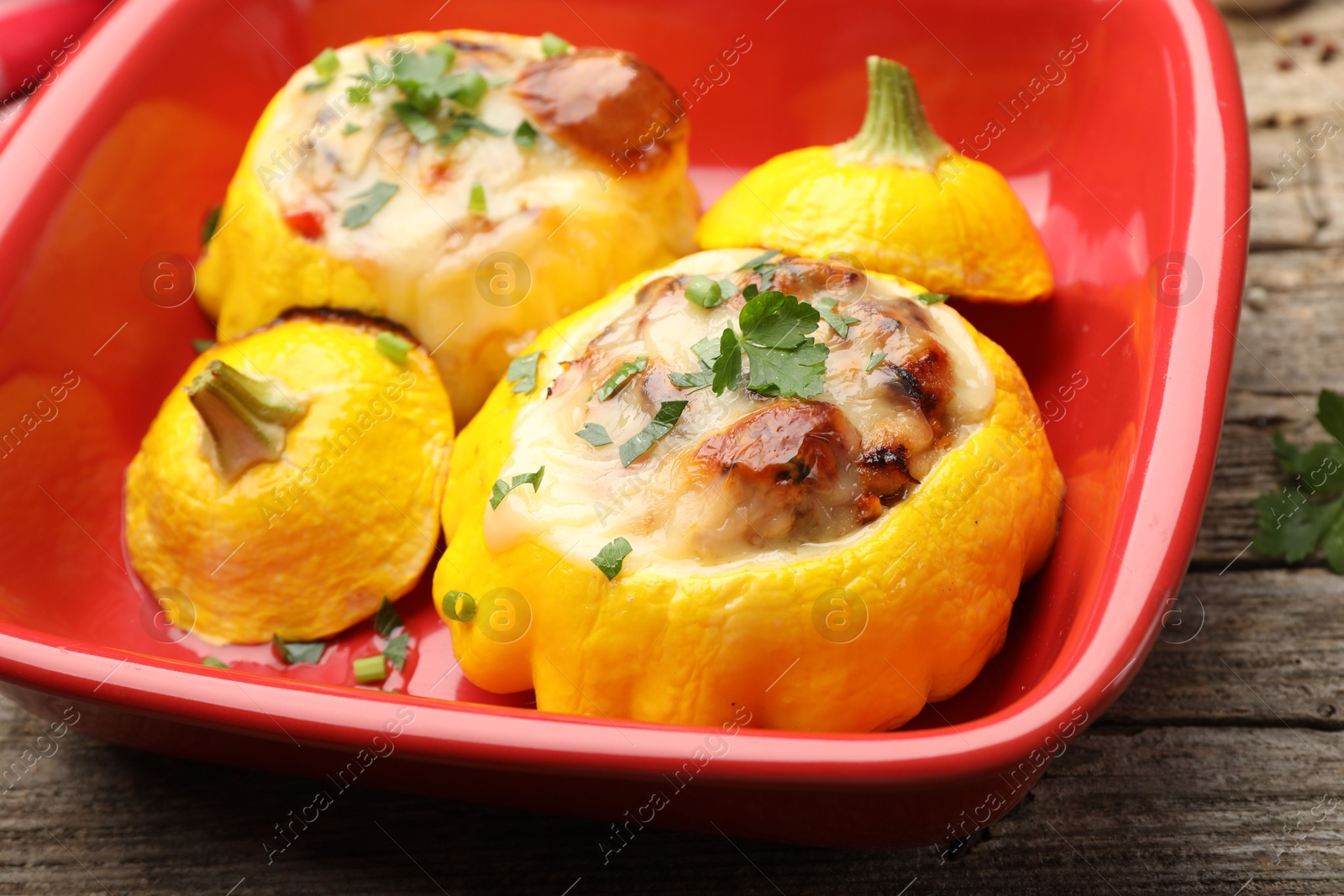 Tasty stuffed pattypan squashes in baking dish on wooden table, closeup Photo of Tasty stuffed pattypan squashes in baking dish on wooden table, closeup