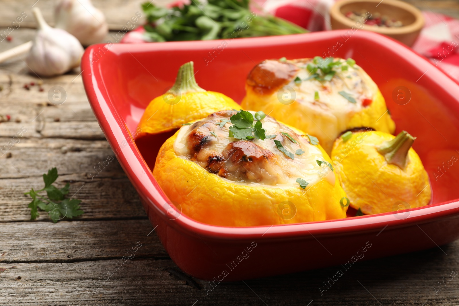 Tasty stuffed pattypan squashes in baking dish on wooden table, closeup Photo of Tasty stuffed pattypan squashes in baking dish on wooden table, closeup