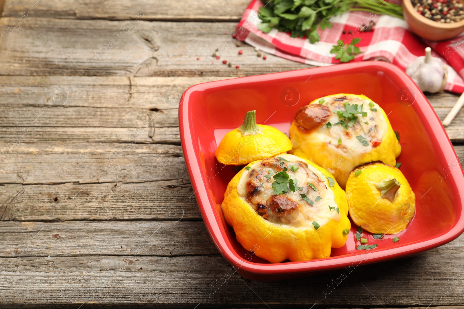 Tasty stuffed pattypan squashes in baking dish on wooden table, closeup. Space for text Photo of Tasty stuffed pattypan squashes in baking dish on wooden table, closeup. Space for text