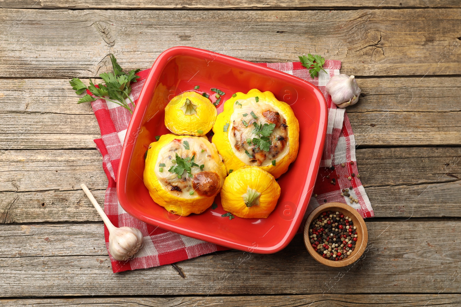 Tasty stuffed pattypan squashes in baking dish and spices on wooden table, flat lay Photo of Tasty stuffed pattypan squashes in baking dish and spices on wooden table, flat lay