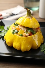 Photo of Tasty stuffed pattypan squash on wooden table, closeup