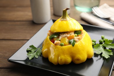 Photo of Tasty stuffed pattypan squash on wooden table, closeup