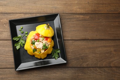 Photo of Tasty stuffed pattypan squash on wooden table, top view. Space for text