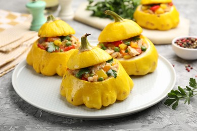 Photo of Tasty stuffed pattypan squashes on grey textured table, closeup