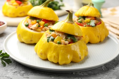Photo of Tasty stuffed pattypan squashes on grey textured table, closeup