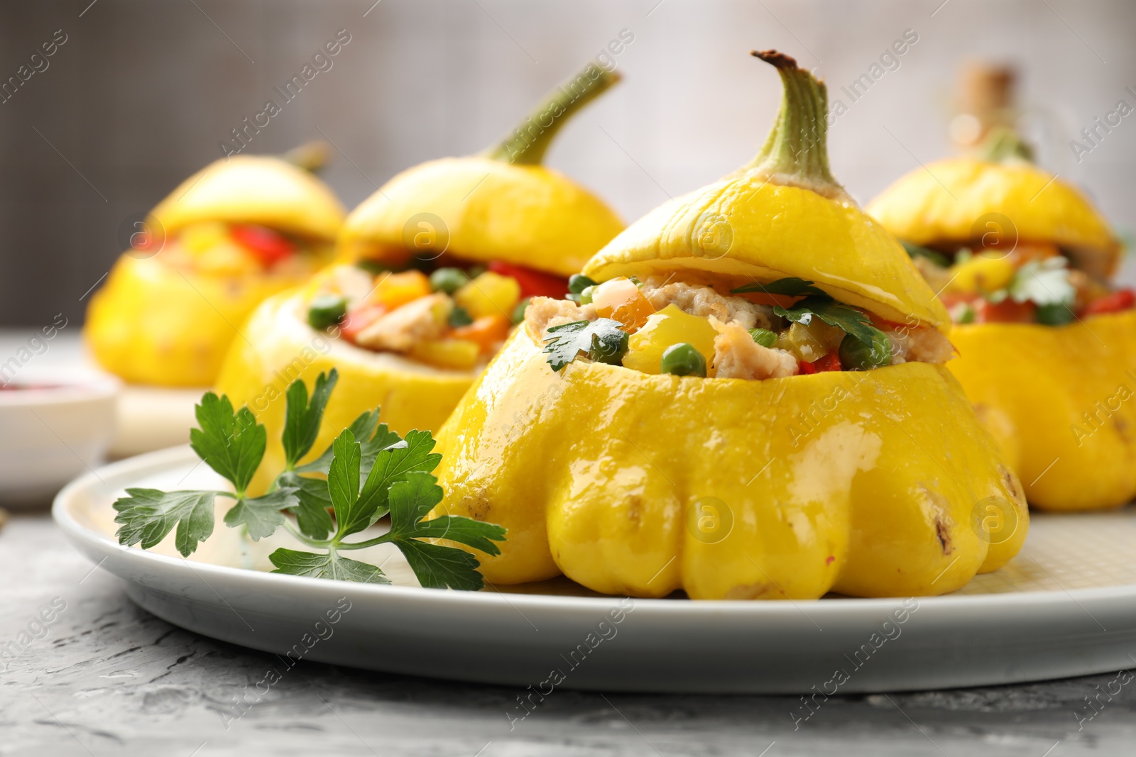 Tasty stuffed pattypan squashes on grey textured table, closeup Photo of Tasty stuffed pattypan squashes on grey textured table, closeup