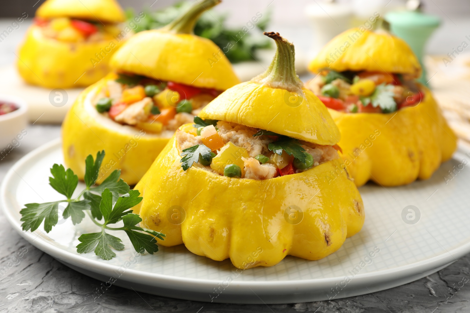 Tasty stuffed pattypan squashes on grey textured table, closeup Photo of Tasty stuffed pattypan squashes on grey textured table, closeup