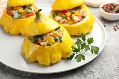 Photo of Tasty stuffed pattypan squashes on grey textured table, closeup