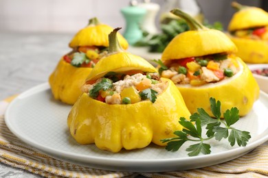 Photo of Tasty stuffed pattypan squashes on grey table, closeup