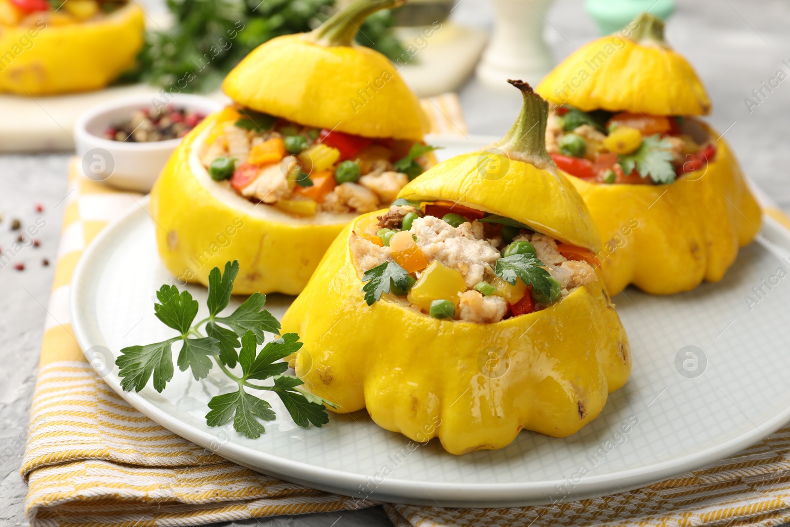 Tasty stuffed pattypan squashes on grey textured table, closeup Photo of Tasty stuffed pattypan squashes on grey textured table, closeup