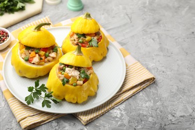 Photo of Tasty stuffed pattypan squashes on grey textured table, closeup