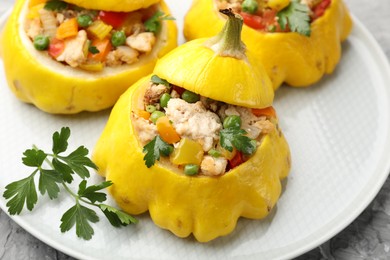 Photo of Tasty stuffed pattypan squashes on grey textured table, closeup