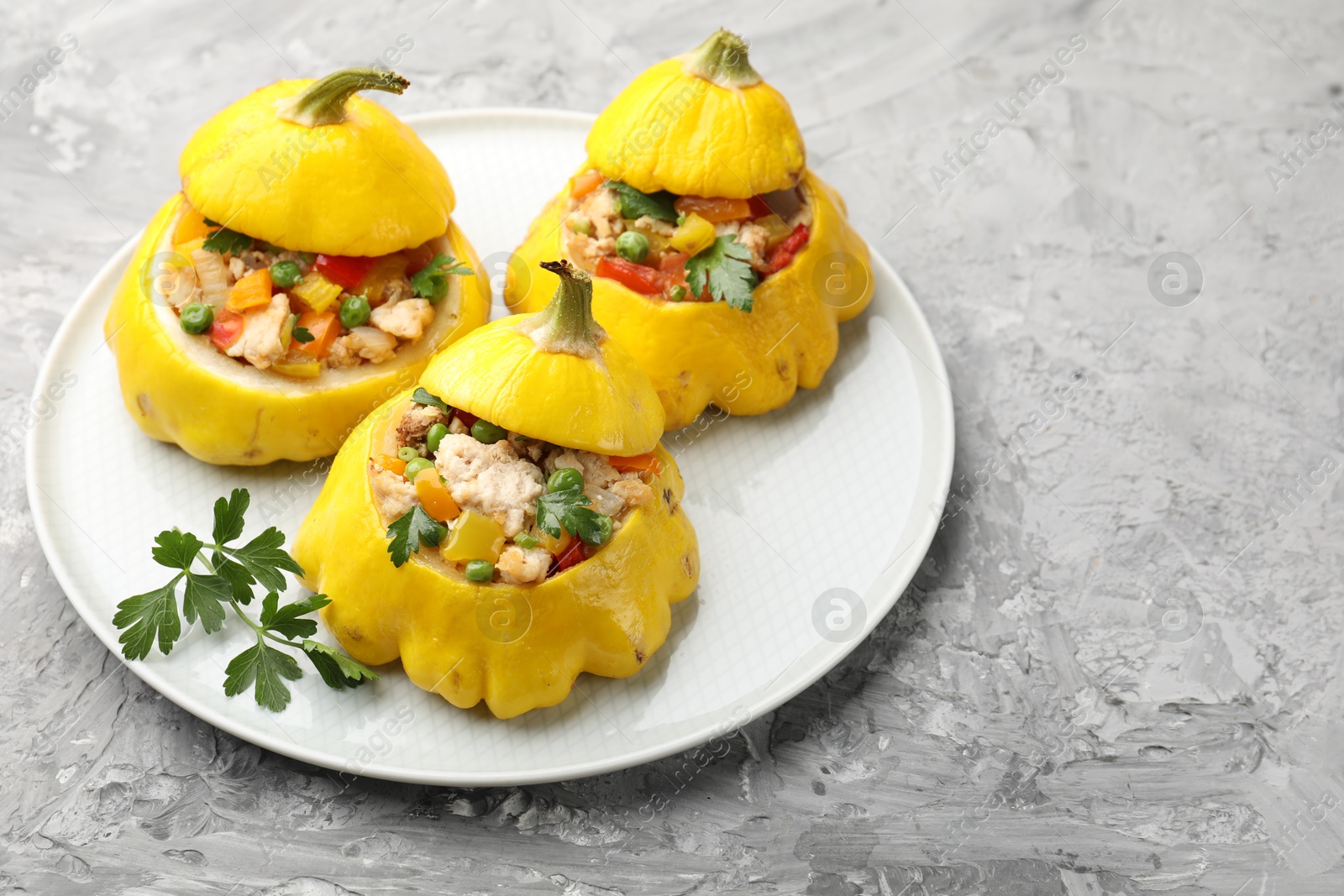 Tasty stuffed pattypan squashes on grey textured table, closeup Photo of Tasty stuffed pattypan squashes on grey textured table, closeup