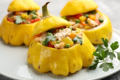 Photo of Tasty stuffed pattypan squashes on grey table, closeup