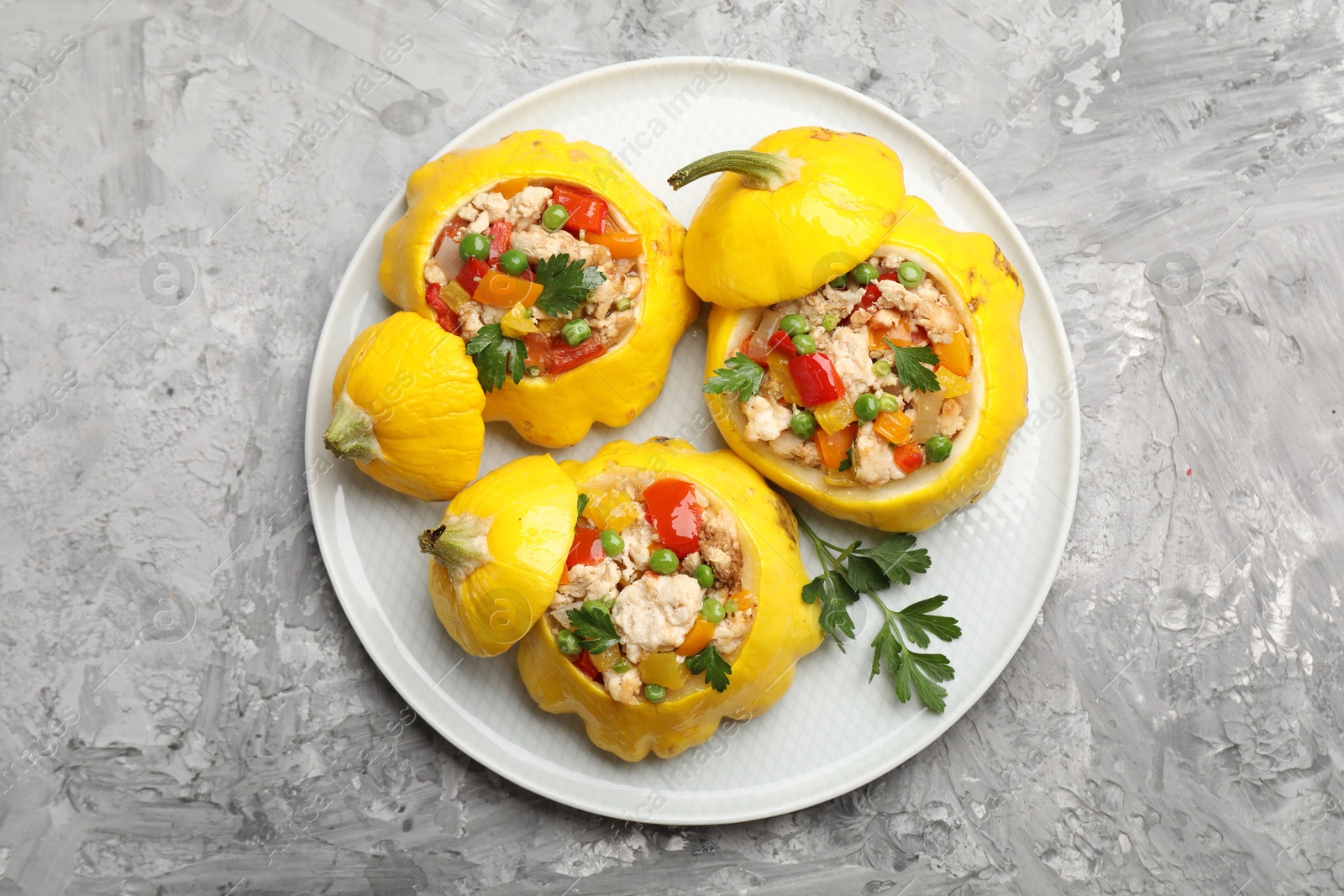 Tasty stuffed pattypan squashes on grey textured table, top view Photo of Tasty stuffed pattypan squashes on grey textured table, top view