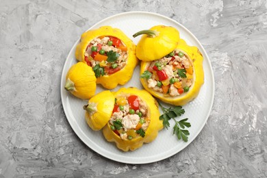 Photo of Tasty stuffed pattypan squashes on grey textured table, top view