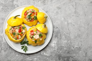 Photo of Tasty stuffed pattypan squashes on grey textured table, top view. Space for text