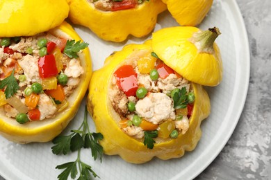 Photo of Tasty stuffed pattypan squashes on grey textured table, top view
