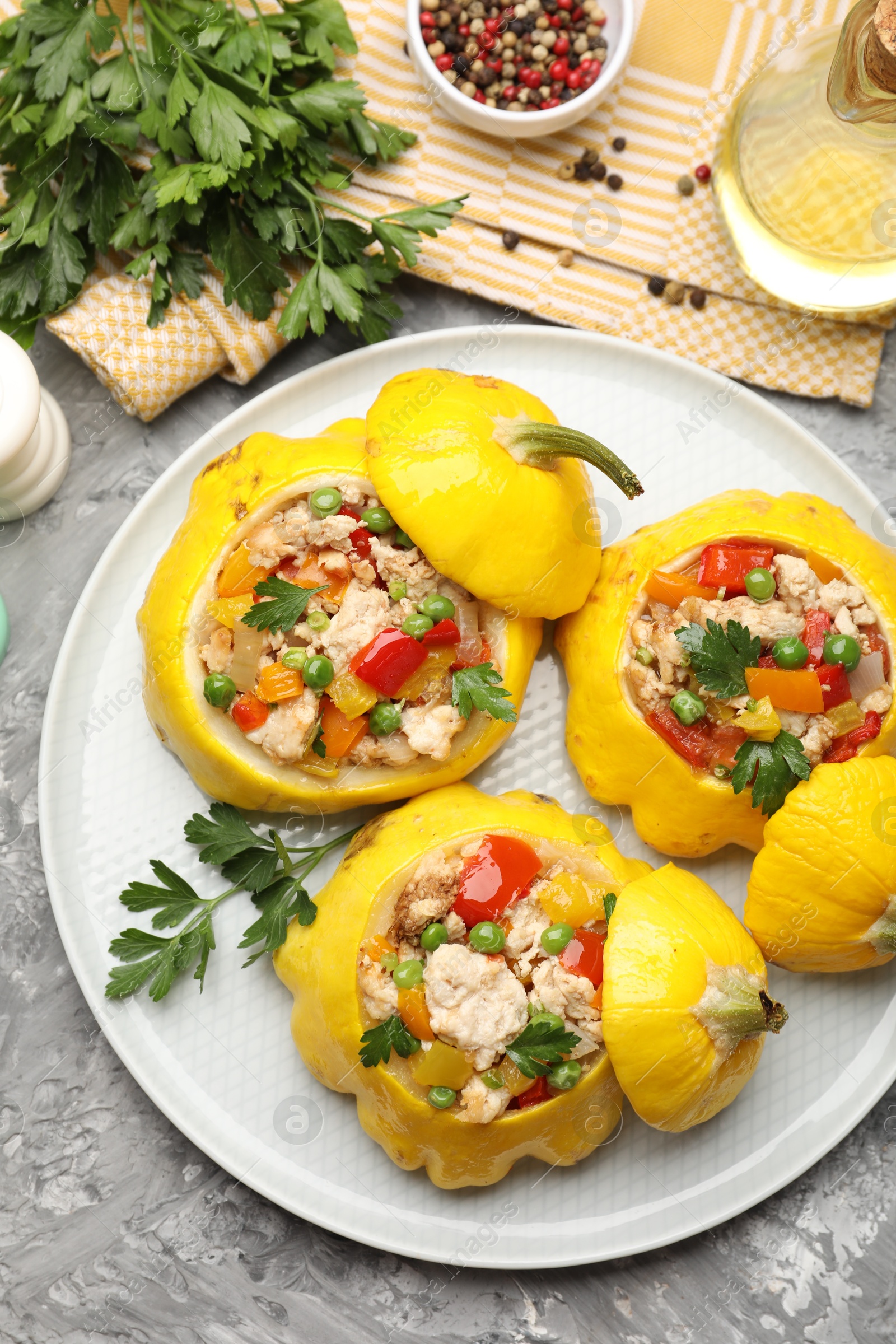 Tasty stuffed pattypan squashes and spices on grey textured table, flat lay Photo of Tasty stuffed pattypan squashes and spices on grey textured table, flat lay