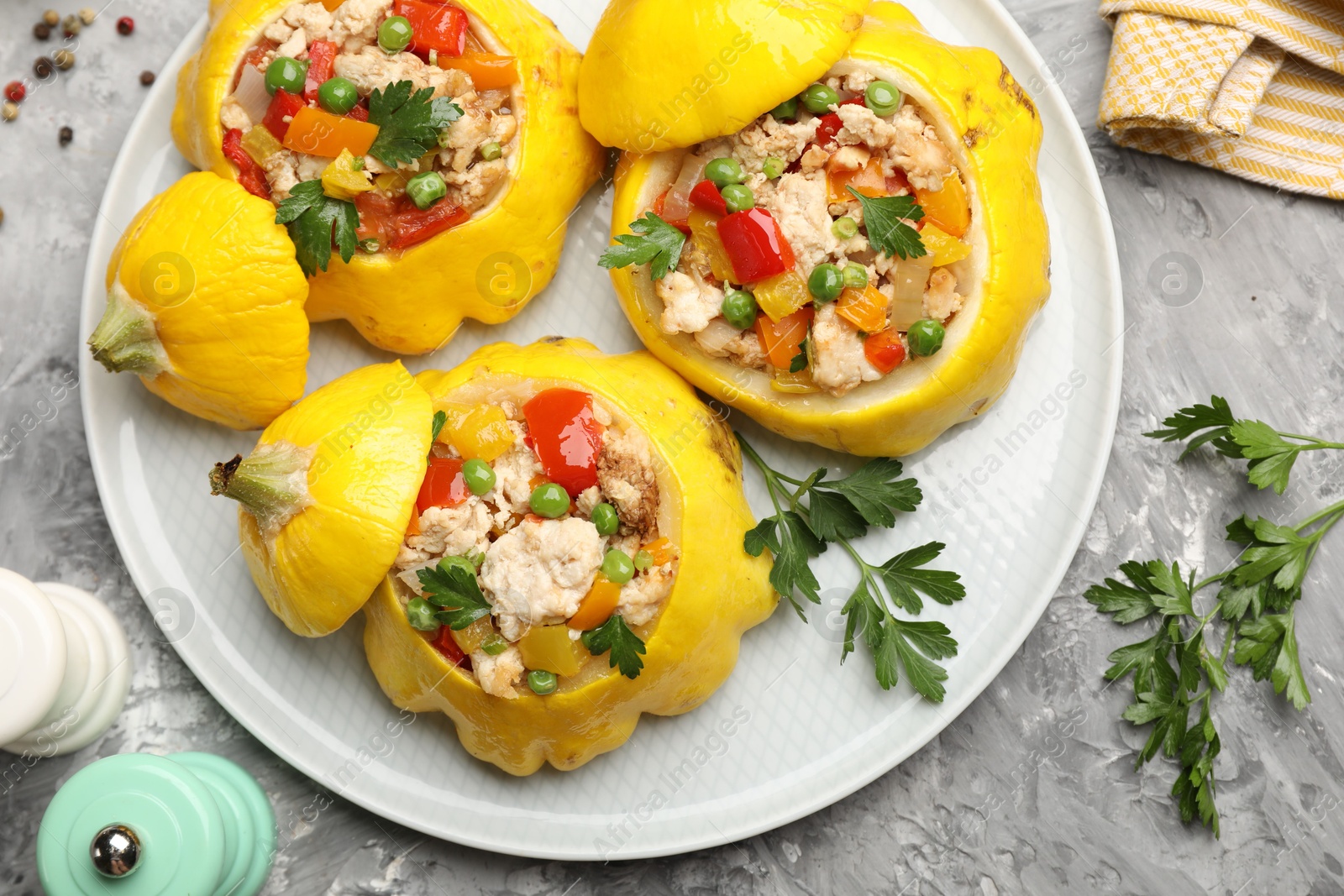 Tasty stuffed pattypan squashes and spices on grey textured table, flat lay Photo of Tasty stuffed pattypan squashes and spices on grey textured table, flat lay