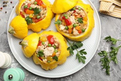 Photo of Tasty stuffed pattypan squashes and spices on grey textured table, flat lay