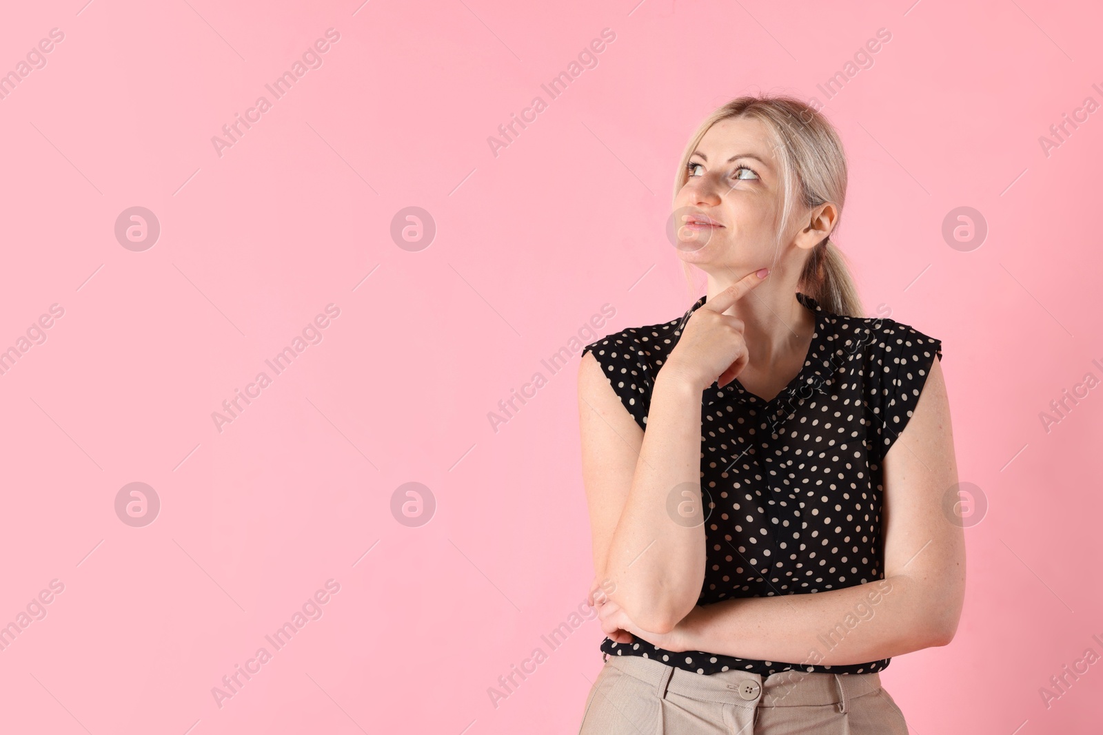 Dreams come true. Woman thinking about something on pink background, space for text Photo of Dreams come true. Woman thinking about something on pink background, space for text