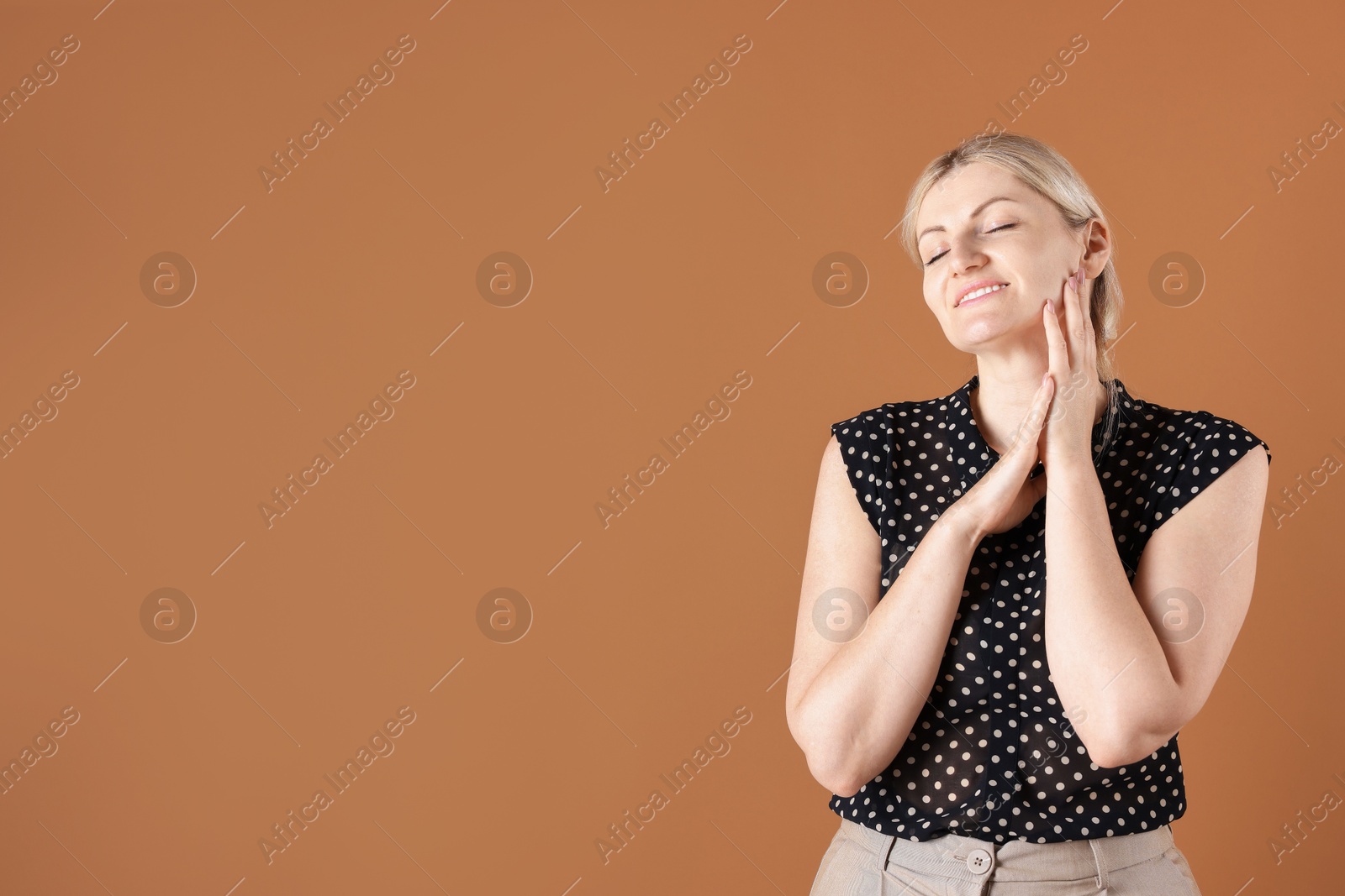Dreams come true. Woman thinking about something on brown background, space for text Photo of Dreams come true. Woman thinking about something on brown background, space for text