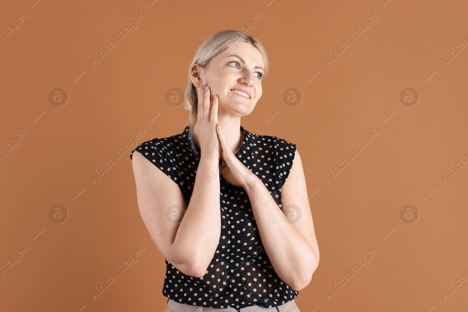 Dreams come true. Woman thinking about something on brown background Photo of Dreams come true. Woman thinking about something on brown background