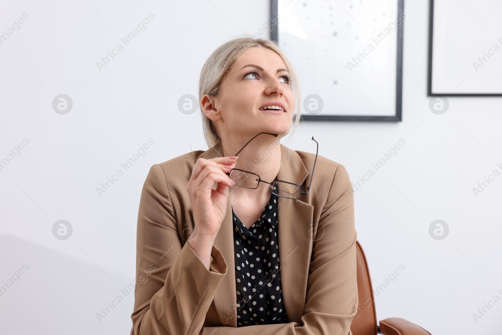 Dreams come true. Woman with glasses thinking about something indoors Photo of Dreams come true. Woman with glasses thinking about something indoors