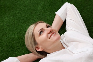 Photo of Dreams come true. Woman thinking about something on green grass outdoors, above view