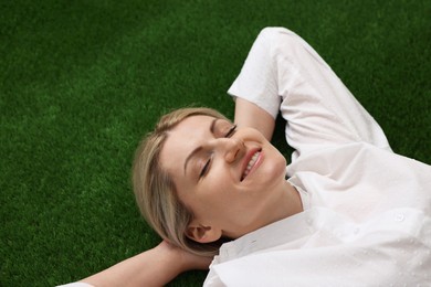 Photo of Dreams come true. Woman thinking about something on green grass outdoors, above view