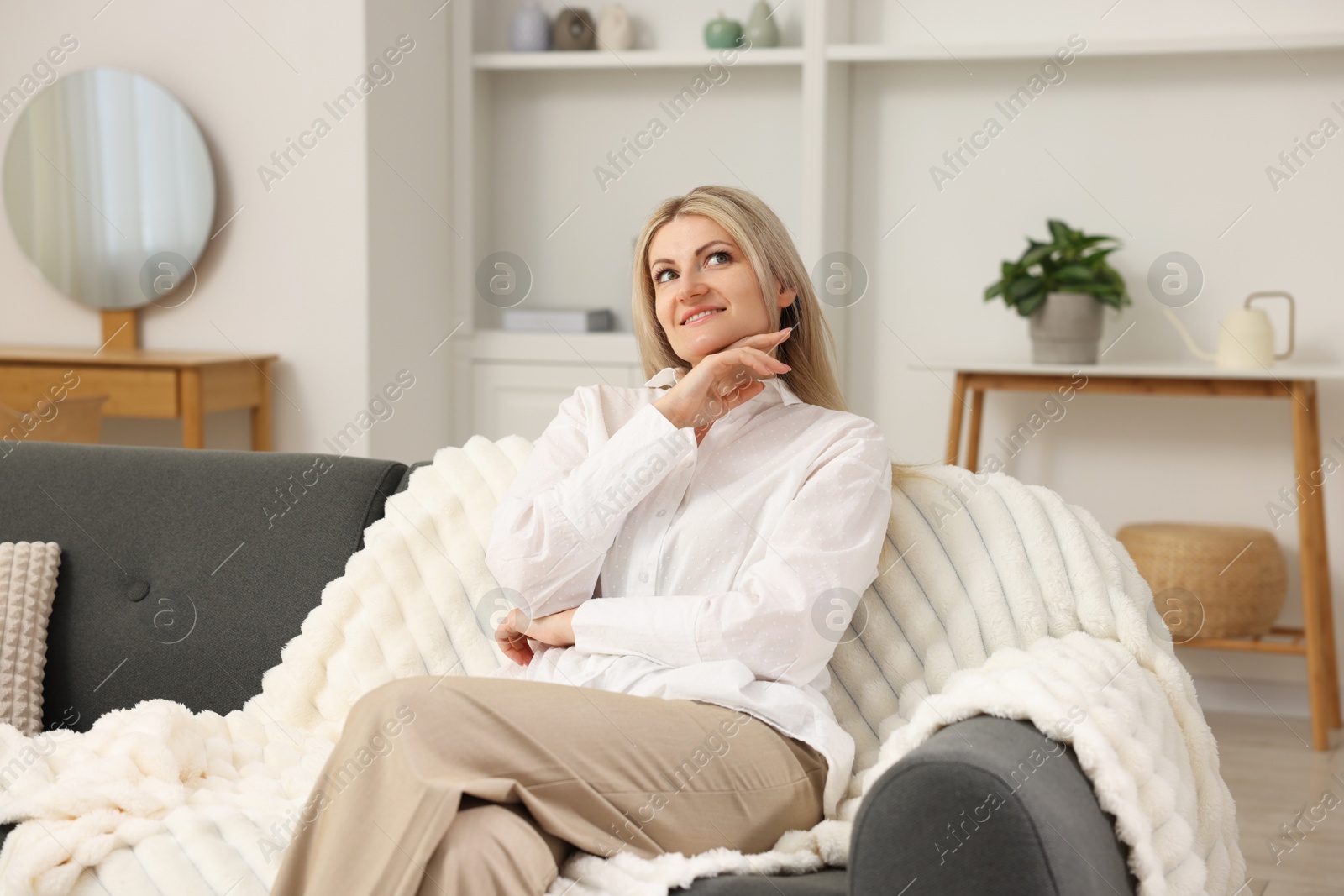 Dreams come true. Woman thinking about something on sofa at home Photo of Dreams come true. Woman thinking about something on sofa at home