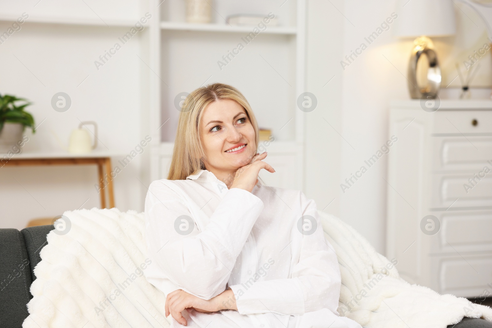 Dreams come true. Woman thinking about something on sofa at home Photo of Dreams come true. Woman thinking about something on sofa at home