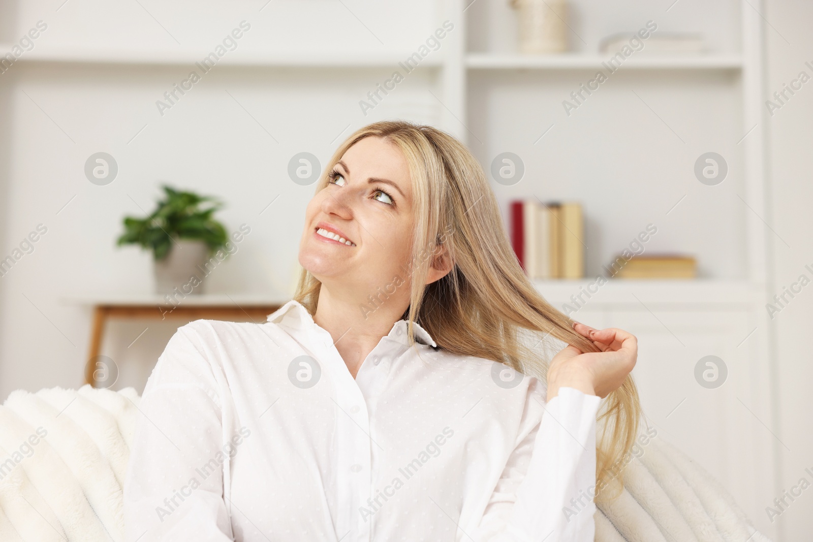 Dreams come true. Woman thinking about something on sofa at home Photo of Dreams come true. Woman thinking about something on sofa at home