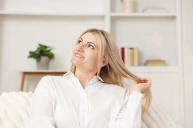 Photo of Dreams come true. Woman thinking about something on sofa at home