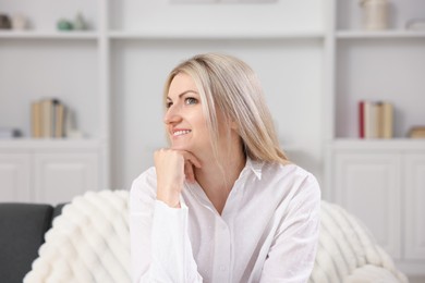 Photo of Dreams come true. Woman thinking about something on sofa at home