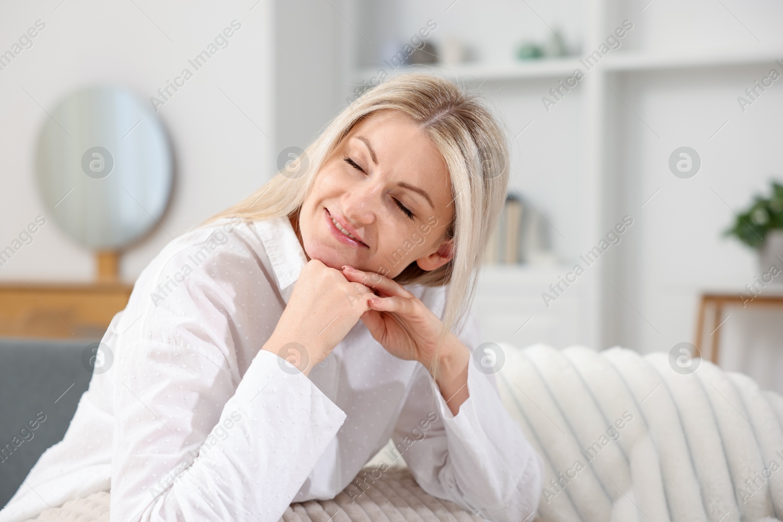 Dreams come true. Woman thinking about something on sofa at home, space for text Photo of Dreams come true. Woman thinking about something on sofa at home, space for text
