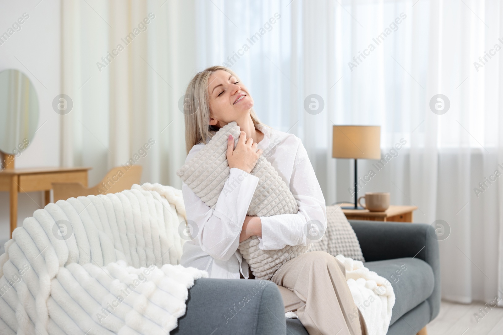 Dreams come true. Woman with pillow thinking about something on sofa at home Photo of Dreams come true. Woman with pillow thinking about something on sofa at home