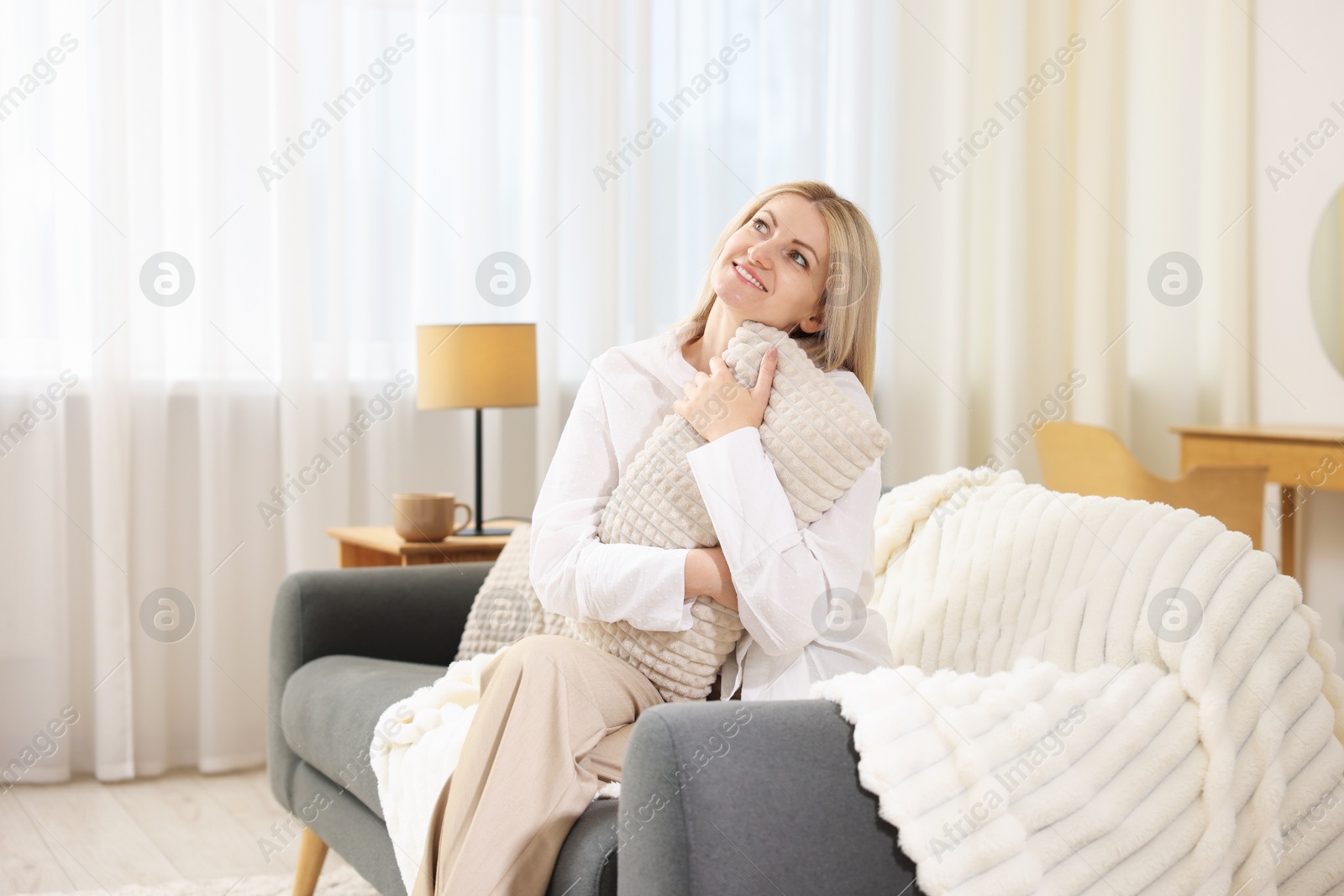 Dreams come true. Woman with pillow thinking about something on sofa at home Photo of Dreams come true. Woman with pillow thinking about something on sofa at home