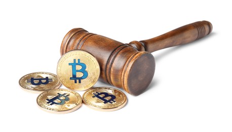 Photo of Cryptocurrency. Bitcoins and judge's gavel isolated on white