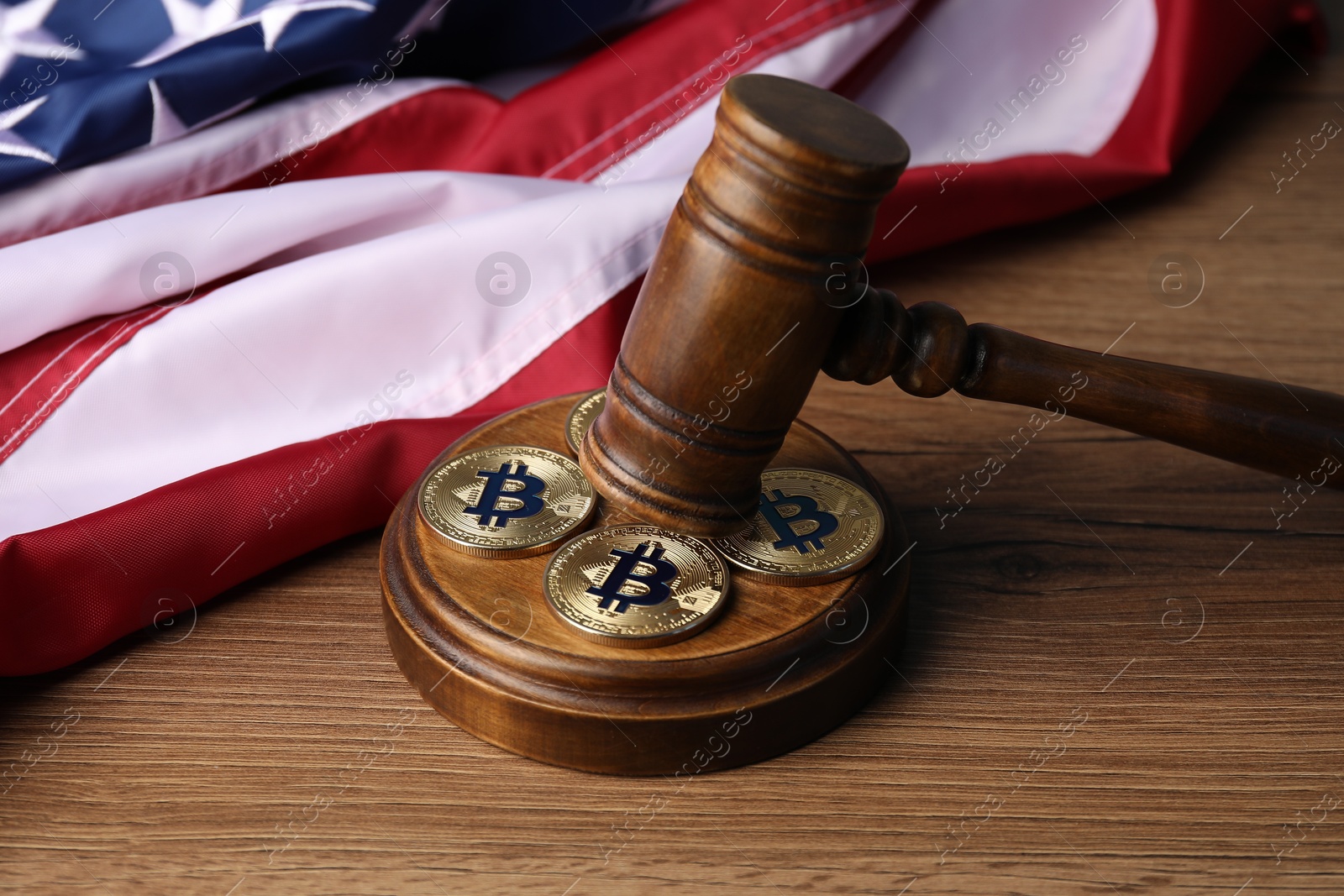 Cryptocurrency. Bitcoins, judge's gavel and American flag on wooden table, closeup Photo of Cryptocurrency. Bitcoins, judge's gavel and American flag on wooden table, closeup
