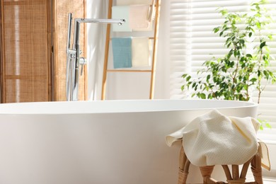 Photo of Clean waffle towel on table near bath indoors