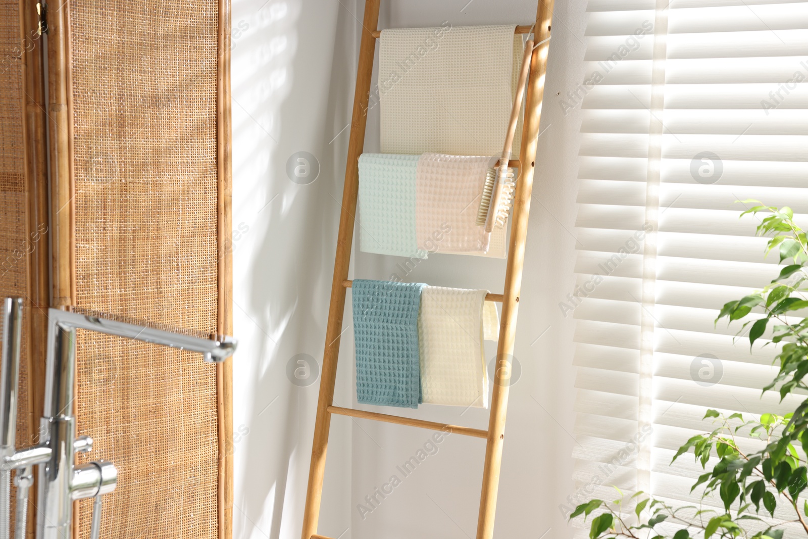 Photo of Fresh clean waffle towels drying on rack in bathroom
