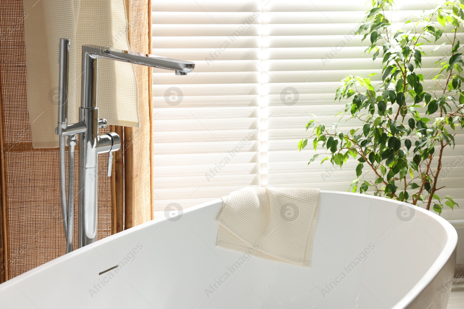 Photo of Fresh clean waffle towel on bath indoors
